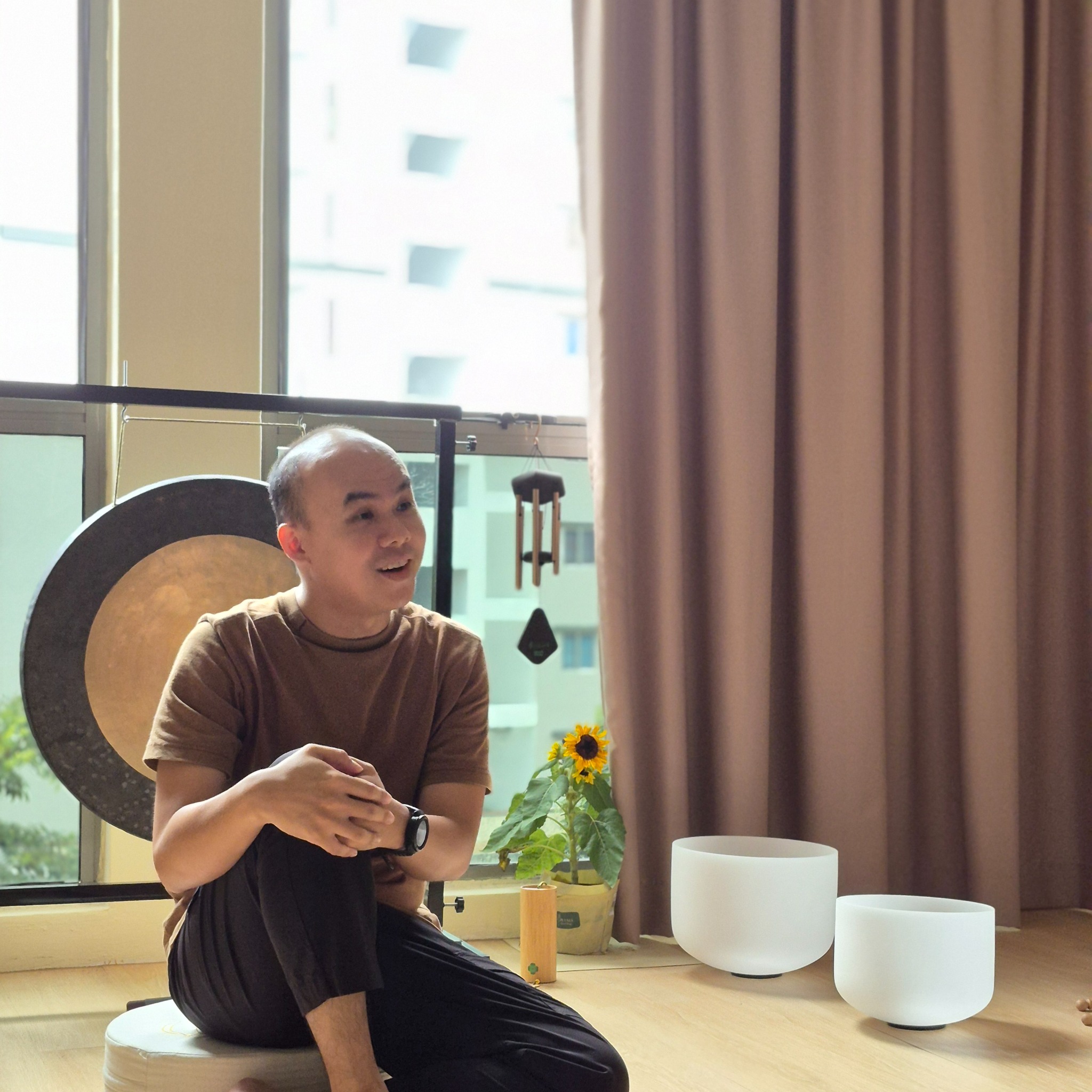 Hong facilitating a breathwork and sound healing session with singing bowls and gong in Malaysia